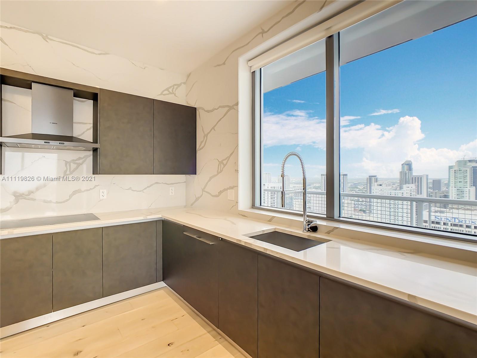 340 Southeast 3rd Street, Unit PH2 Miami, FL 33131 - Photo 11 of 54 a bathroom with a sink and a large mirror