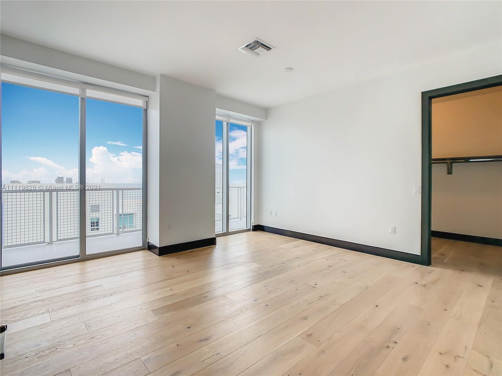 340 Southeast 3rd Street, Unit PH2 Miami, FL 33131 - Photo 15 of 54 a view of an empty room and wooden floor