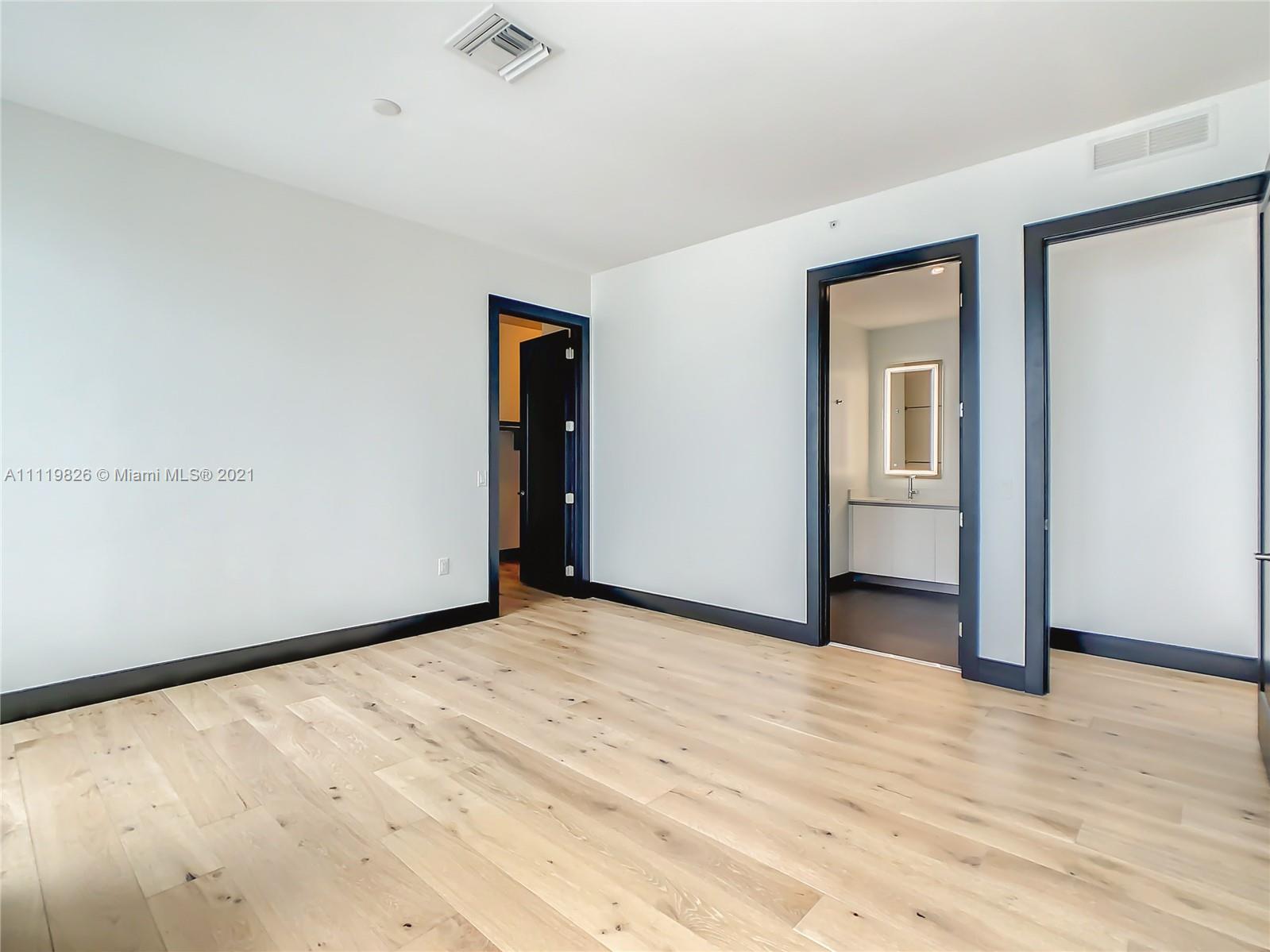 340 Southeast 3rd Street, Unit PH2 Miami, FL 33131 - Photo 16 of 54 a view of an empty room with wooden floor and a window