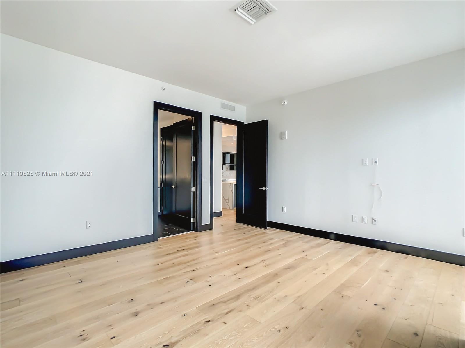 340 Southeast 3rd Street, Unit PH2 Miami, FL 33131 - Photo 17 of 54 a view of an empty room with wooden floor