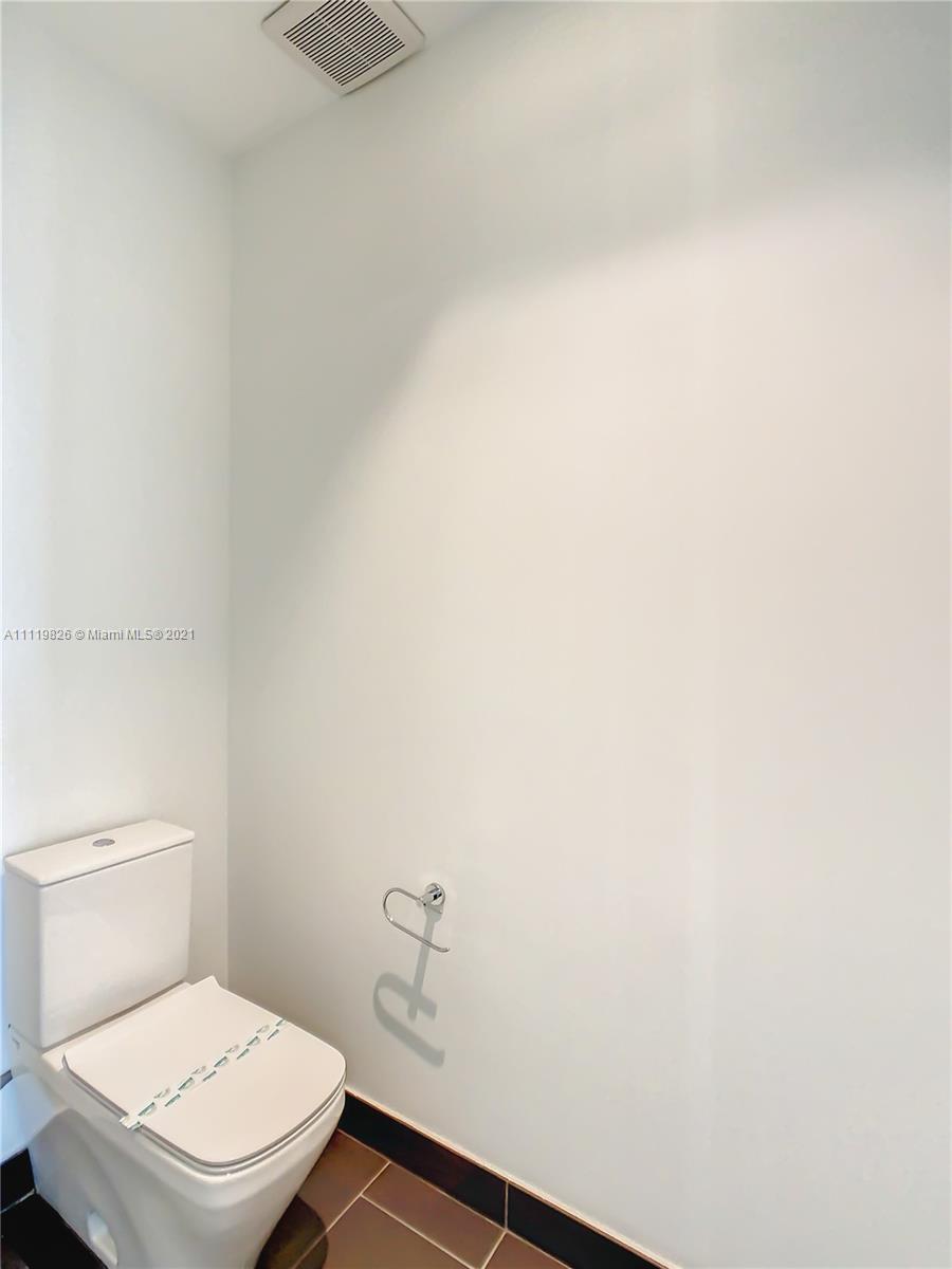 340 Southeast 3rd Street, Unit PH2 Miami, FL 33131 - Photo 21 of 54 a white toilet sitting next to a white wall