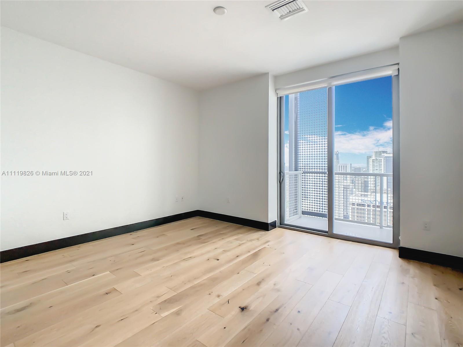 340 Southeast 3rd Street, Unit PH2 Miami, FL 33131 - Photo 22 of 54 a view of an empty room with wooden floor and next to a window