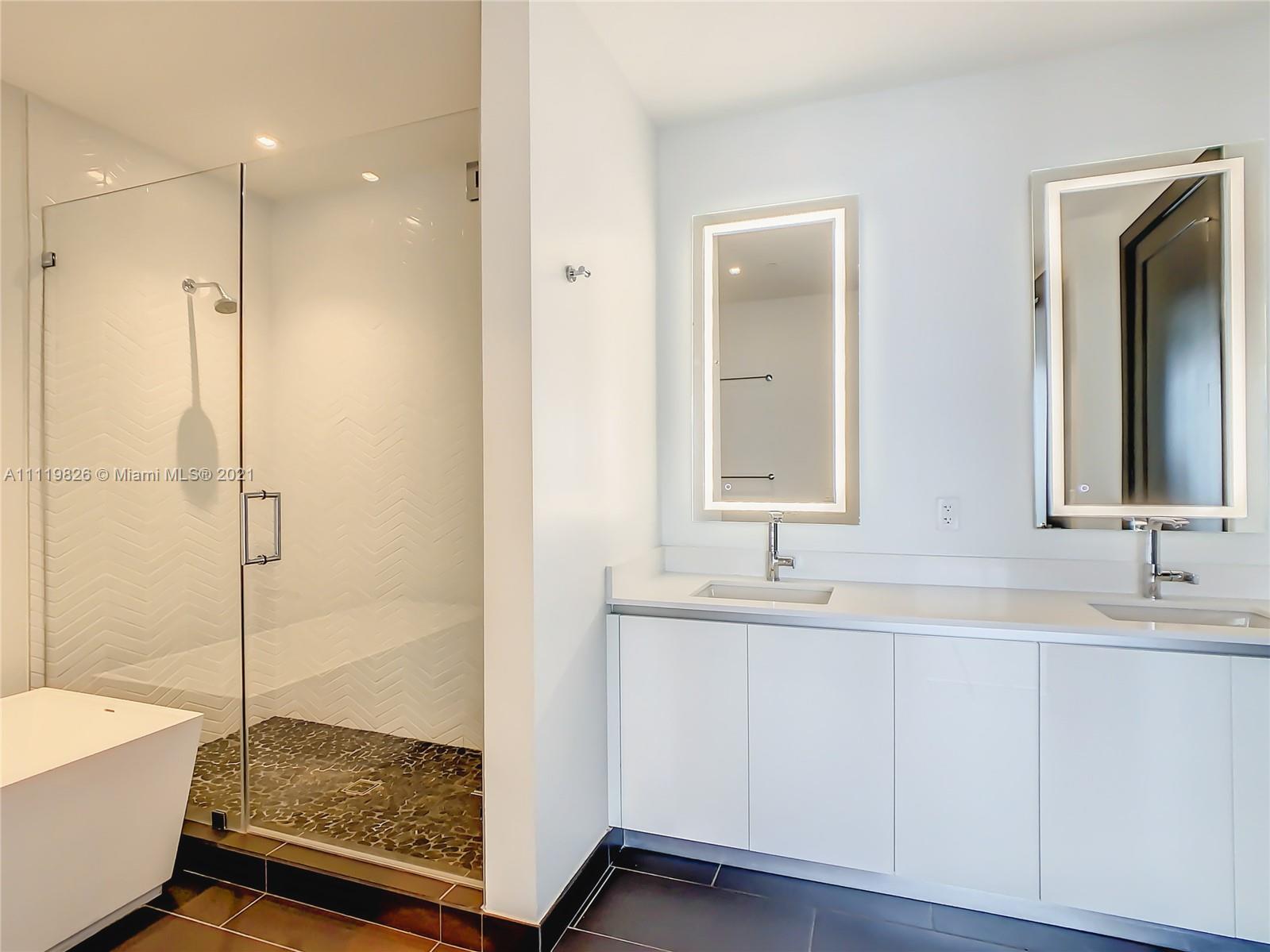 340 Southeast 3rd Street, Unit PH2 Miami, FL 33131 - Photo 25 of 54 a bathroom with a double vanity sink mirror and shower