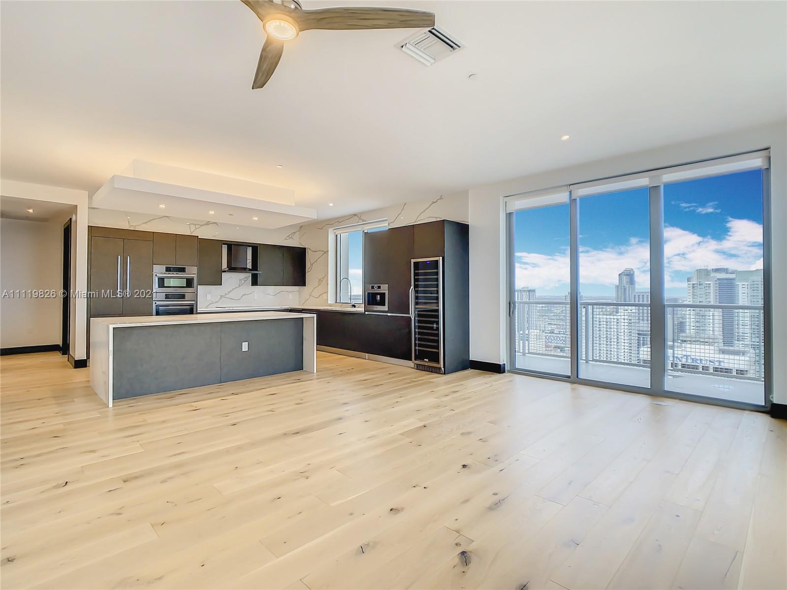340 Southeast 3rd Street, Unit PH2 Miami, FL 33131 - Photo 6 of 54 a large kitchen with stainless steel appliances kitchen island a large counter top and a refrigerator