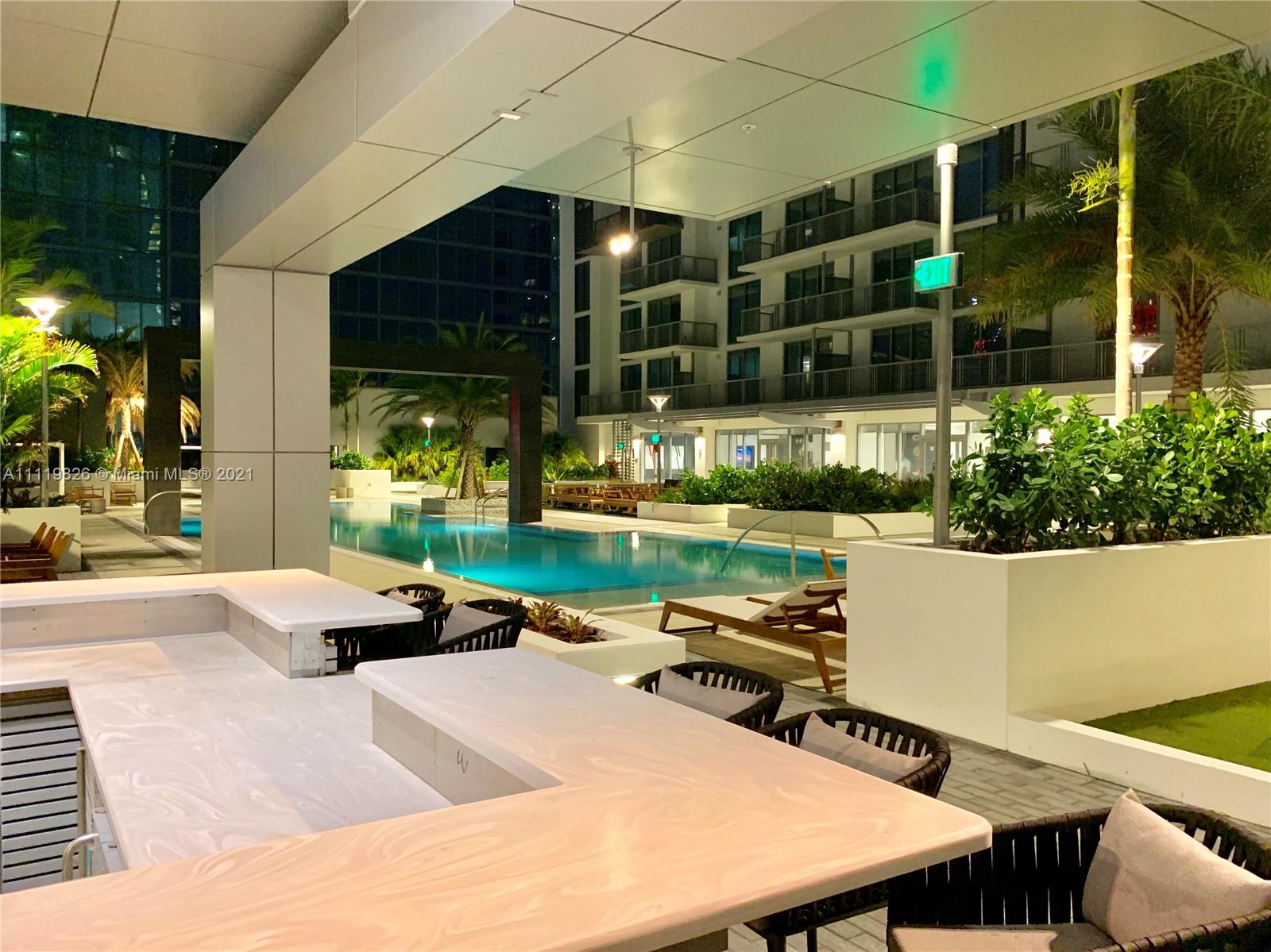 340 Southeast 3rd Street, Unit PH2 Miami, FL 33131 - Photo 52 of 54 a view of a patio with table and chairs and potted plants