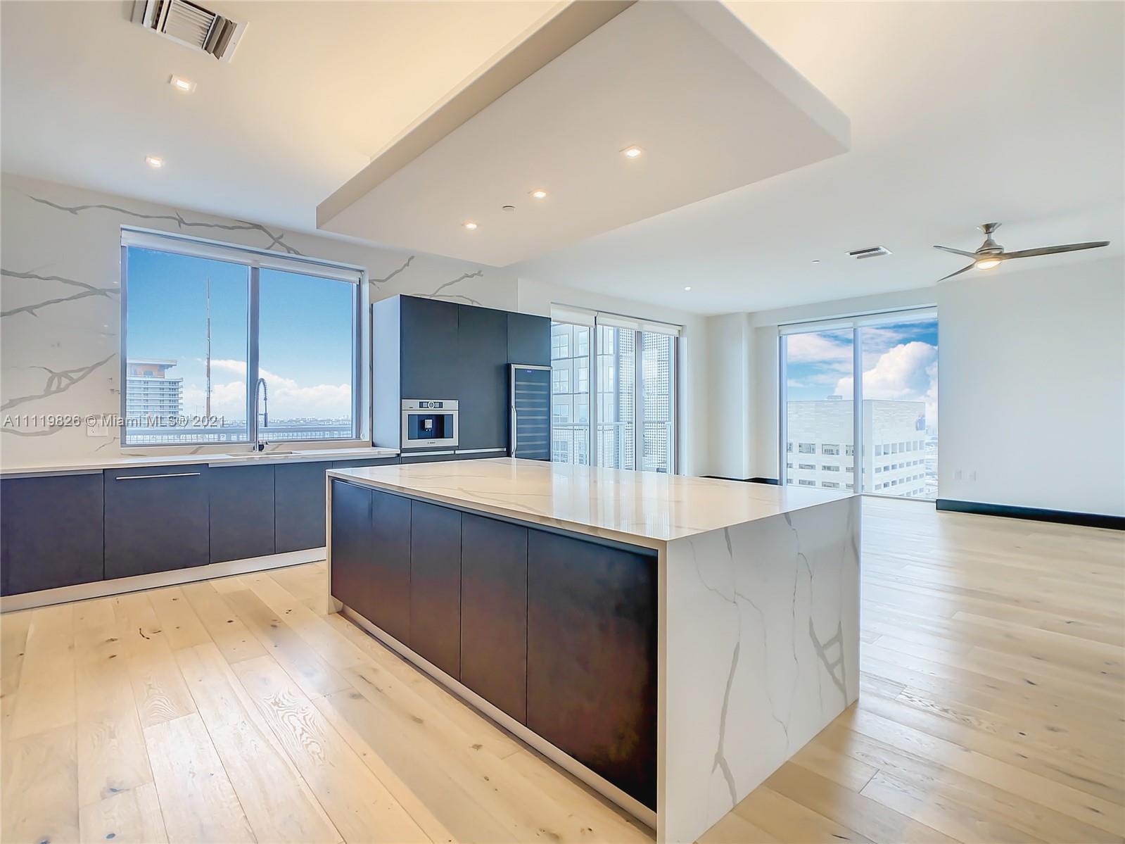340 Southeast 3rd Street, Unit PH2 Miami, FL 33131 - Photo 8 of 54 a large kitchen with stainless steel appliances granite countertop a large counter top a sink and a wooden floors