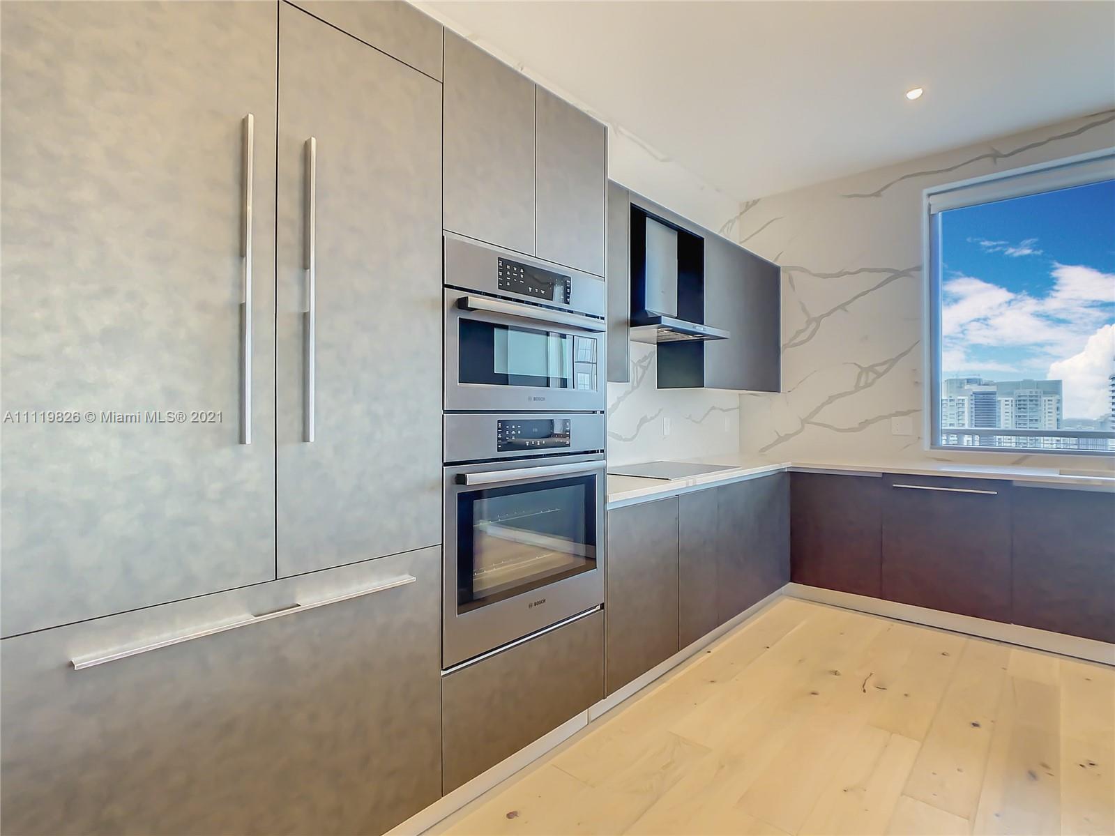 340 Southeast 3rd Street, Unit PH2 Miami, FL 33131 - Photo 9 of 54 a kitchen with stainless steel appliances a refrigerator and a stove top oven