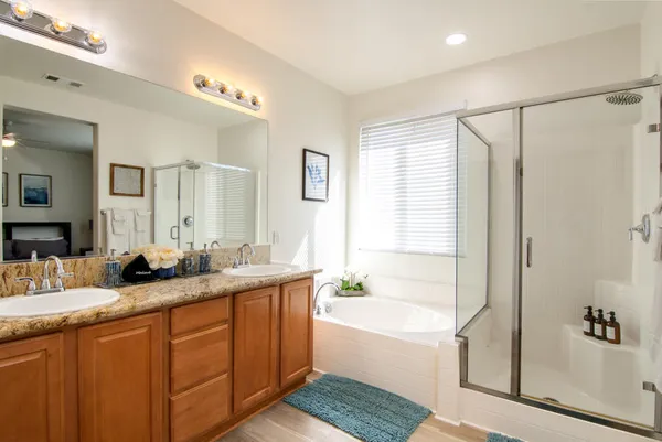 a bathroom with double vanity and a bathtub