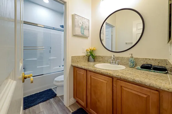 a bathroom with a granite countertop sink and cabinets