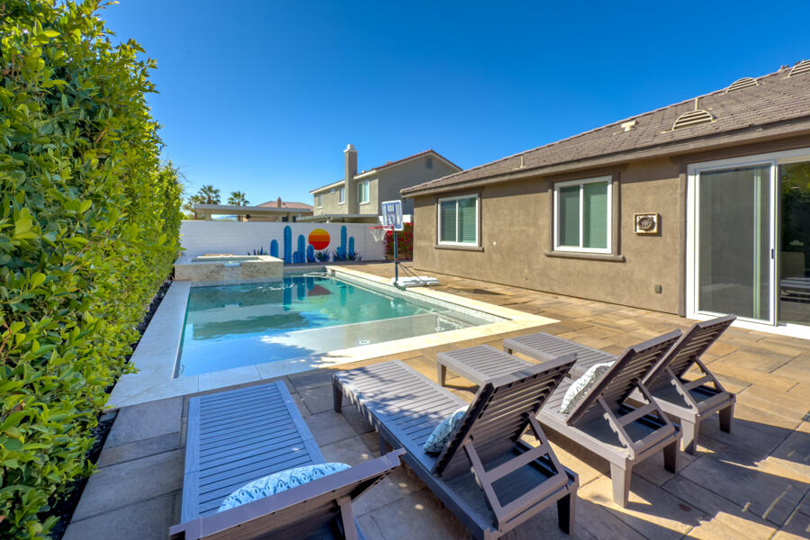 43784 Riunione Place Indio, CA 92203 - Photo 26 of 54 a view of a patio with dining table and chairs with wooden floor and fence