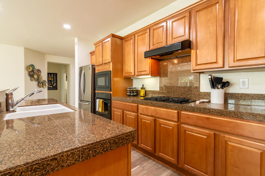 43784 Riunione Place Indio, CA 92203 - Photo 9 of 54 a kitchen with stainless steel appliances granite countertop a sink and cabinets