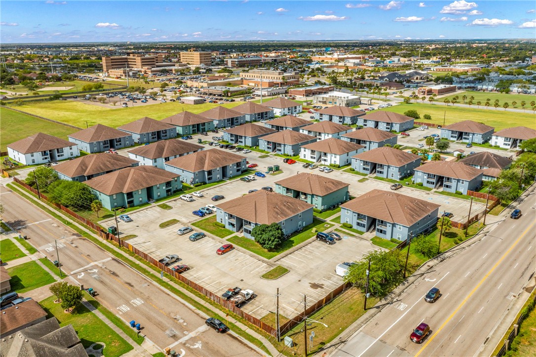 an aerial view of residential houses with outdoor space and ocean view