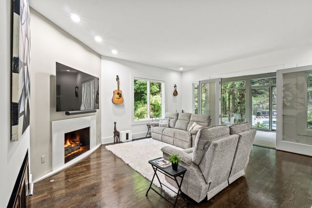 a view of a patio with table and chairs potted plants with wooden floor and floor to ceiling window