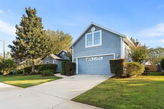 a front view of a house with a yard and trees