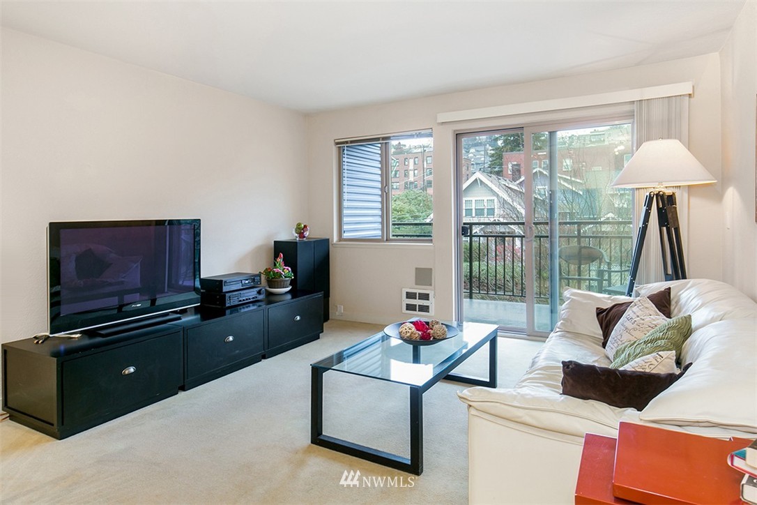 275 West Roy Street, Unit 319 Seattle, WA 98119 - Photo 2 of 18 a living room with furniture and a flat screen tv