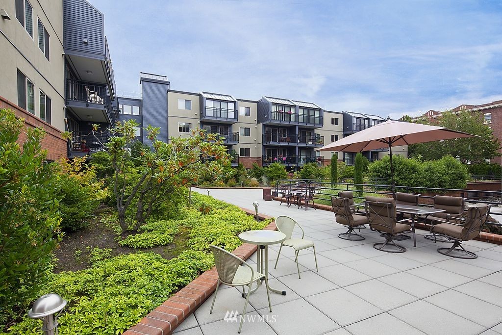 275 West Roy Street, Unit 319 Seattle, WA 98119 - Photo 13 of 18 a view of a patio with furniture and a table and chairs under an umbrella