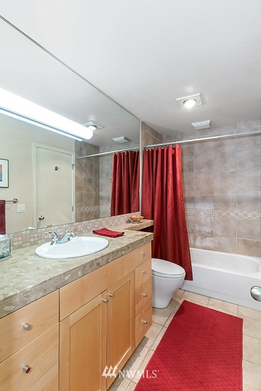 275 West Roy Street, Unit 319 Seattle, WA 98119 - Photo 9 of 18 a bathroom with a granite countertop sink and a mirror