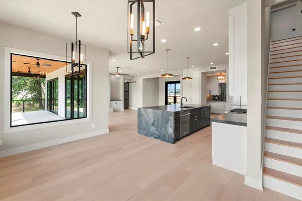 a large kitchen with kitchen island a large counter top space a sink stainless steel appliances and cabinets