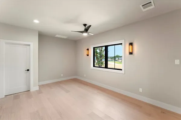 an empty room with a window and a ceiling fan