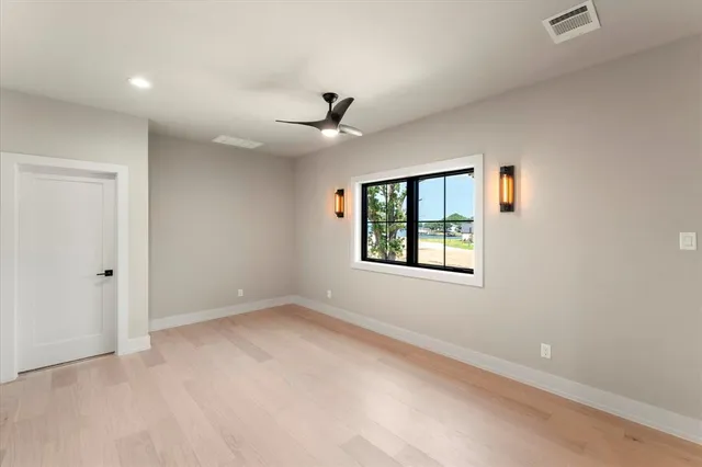 an empty room with a window and a ceiling fan