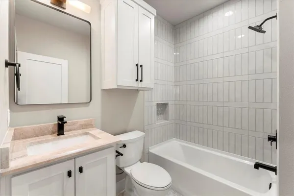 a bathroom with a sink toilet vanity and shower
