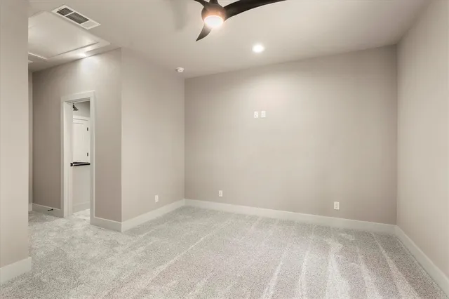 en empty room with ceiling fan and window