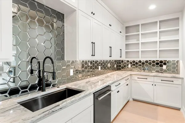 a kitchen with granite countertop white cabinets and appliances