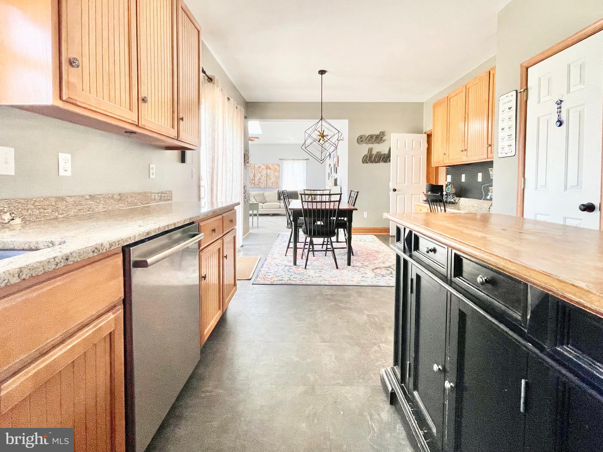 78 Jillian Drive Dover, DE 19901 - Photo 13 of 42 a kitchen with stainless steel appliances granite countertop a stove top oven a sink dishwasher a dining table and chairs with wooden floor