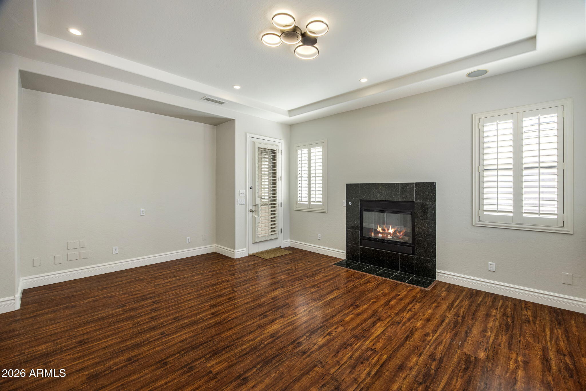 3215 East Constance Way Phoenix, AZ 85042 - Photo 13 of 40 an empty room with windows fireplace and wooden floor