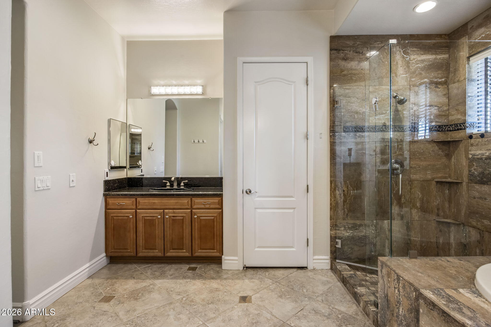 3215 East Constance Way Phoenix, AZ 85042 - Photo 23 of 40 a bathroom with a granite countertop sink a mirror and a shower