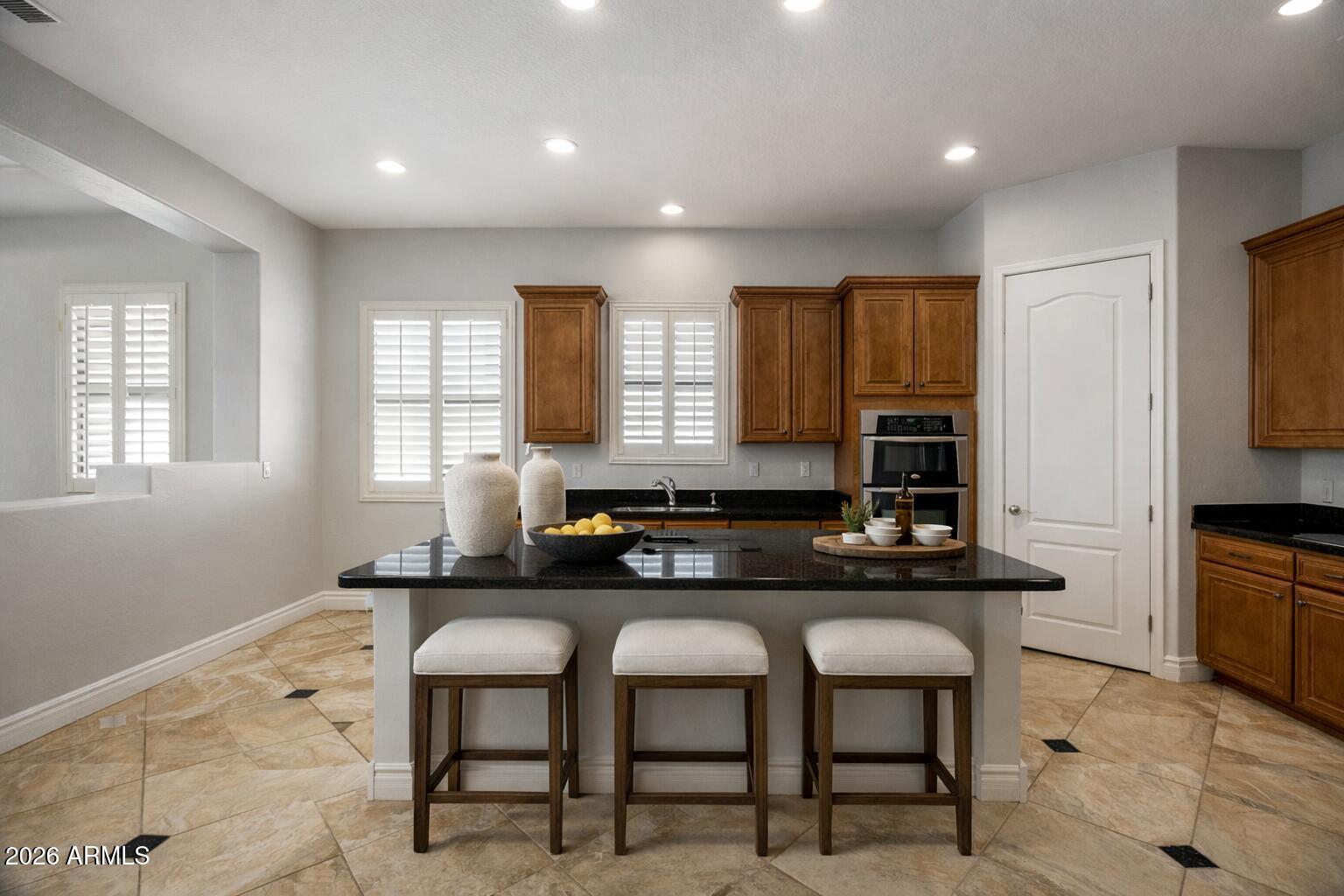 3215 East Constance Way Phoenix, AZ 85042 - Photo 6 of 40 a kitchen with granite countertop a sink and chairs