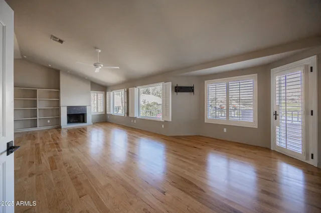 an empty room with wooden floor and fireplace