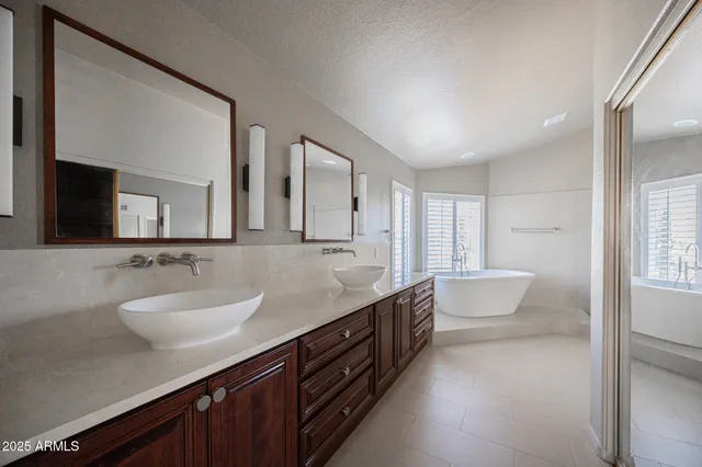a spacious bathroom with a granite countertop sink mirror and bathtub