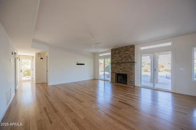 a view of a livingroom with wooden floor and a fireplace