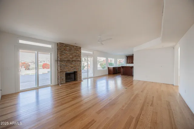 a view of a livingroom with wooden floor and a fireplace