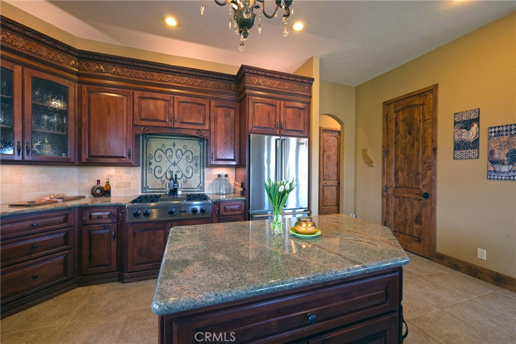 38101 Vía Lobato Temecula, CA 92592 - Photo 26 of 67 a kitchen with wooden cabinets and center island