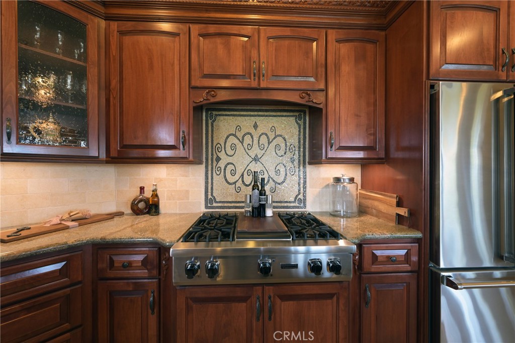 38101 Vía Lobato Temecula, CA 92592 - Photo 28 of 67 a kitchen with stainless steel appliances granite countertop a stove and a refrigerator with wooden cabinets