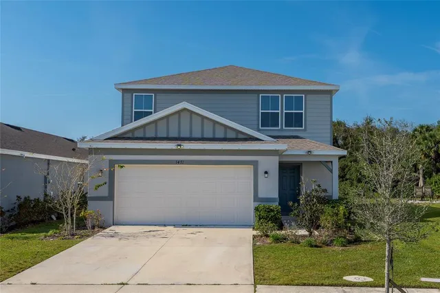 a front view of a house with a yard and garage