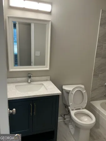 a bathroom with a toilet a sink and mirror