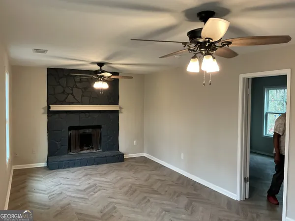 an empty room with a fireplace and fan