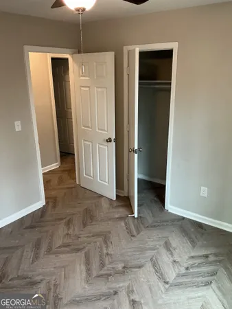 an empty room with closet and a hallway