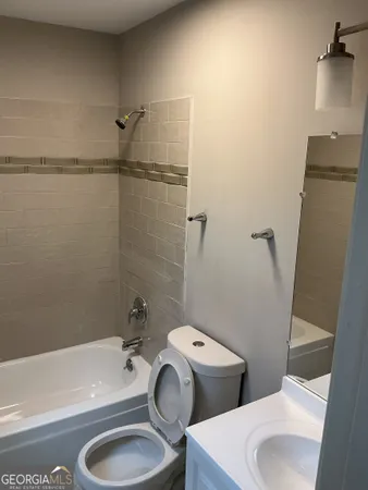 a white toilet sitting next to a bath tub and a sink
