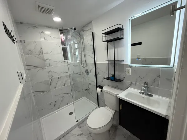 a bathroom with a sink a toilet and shower