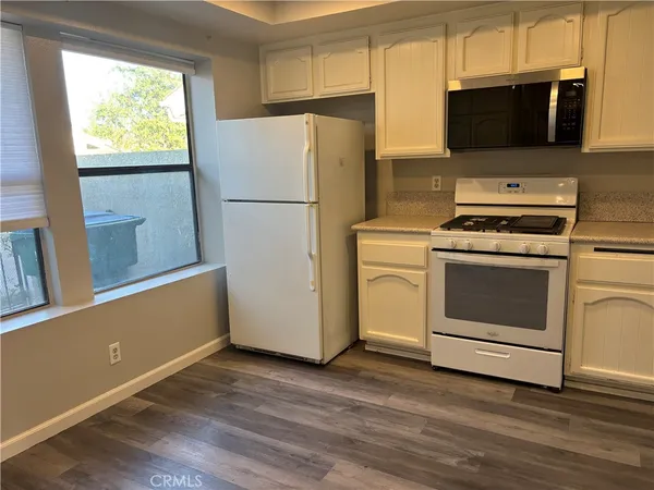 a kitchen with a stove a refrigerator and a microwave