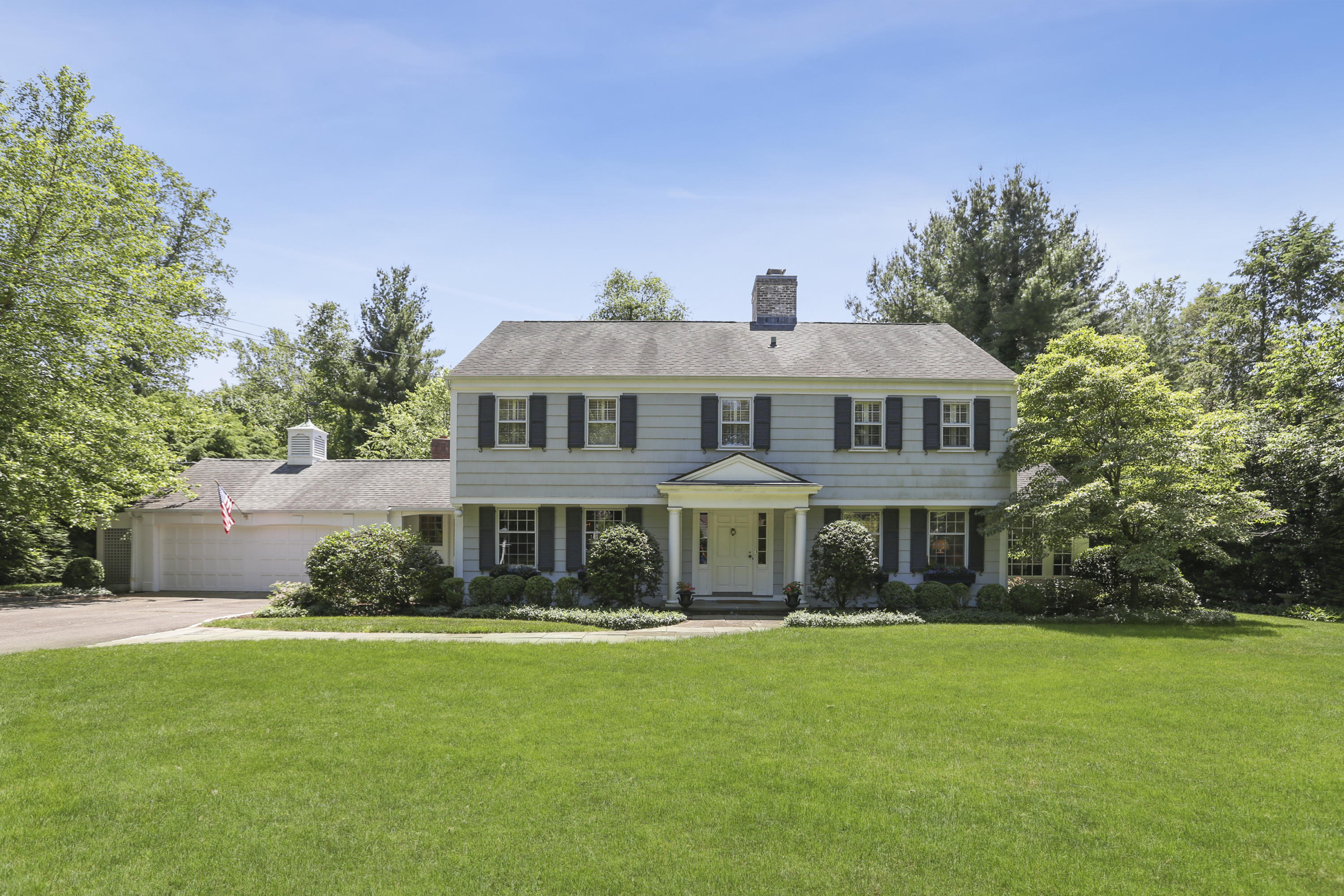 10 Deepwood Road Darien, CT 06820 - Photo 1 of 38 a front view of a house with a yard table and chairs