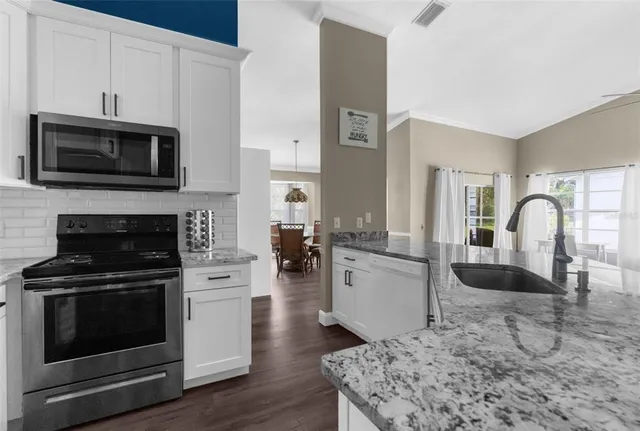 a kitchen with sink a microwave and stove