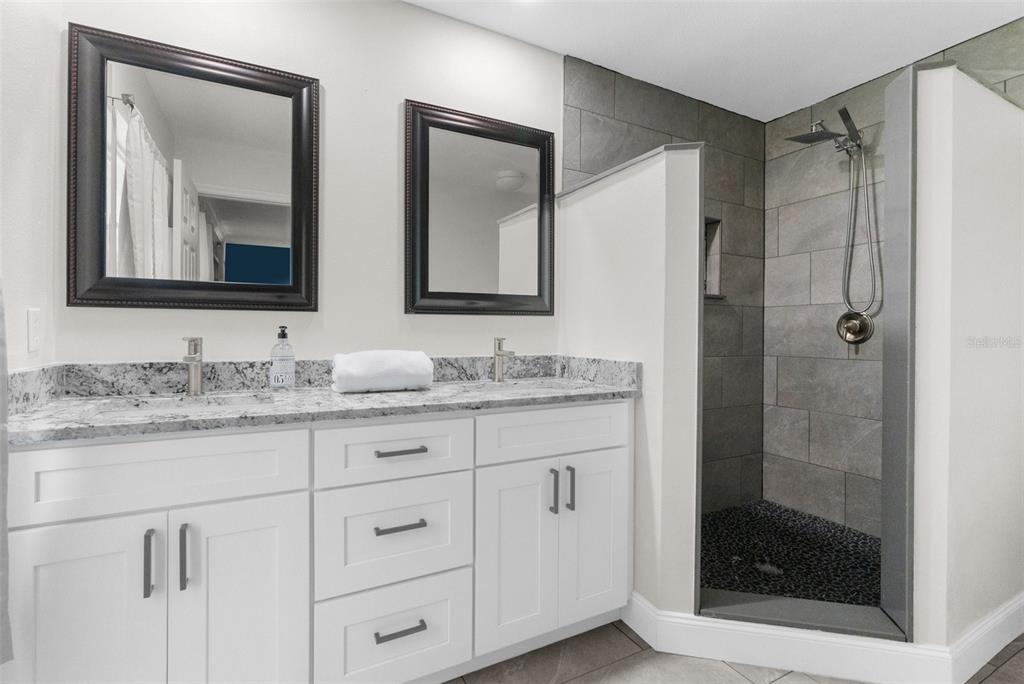 13119 Topflite Court Hudson, FL 34669 - Photo 16 of 26 a bathroom with a granite countertop sink a mirror and shower