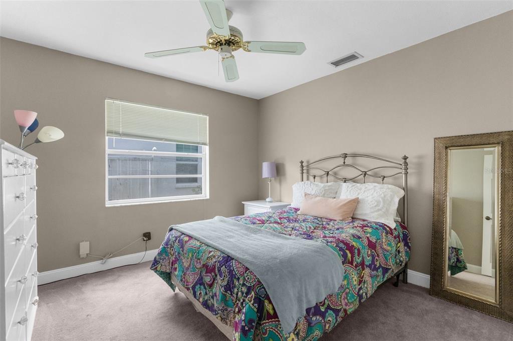 13119 Topflite Court Hudson, FL 34669 - Photo 17 of 26 a bedroom with a bed and a chandelier