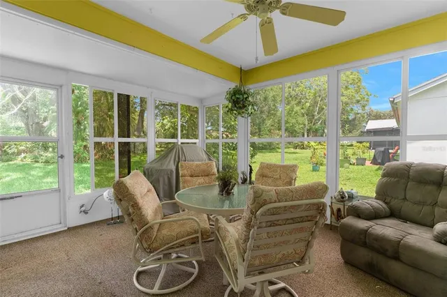 a living room with furniture and a floor to ceiling window