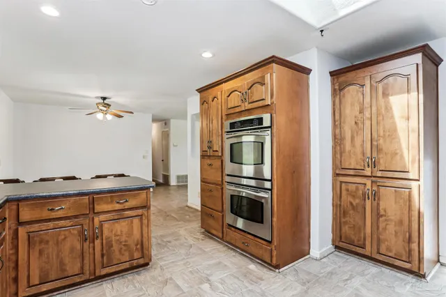 a kitchen with stainless steel appliances granite countertop a refrigerator a stove and a sink